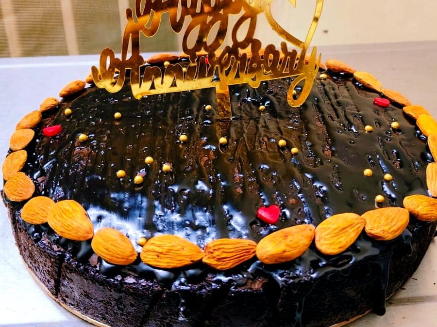 Glazed chocolate celebration cake ringed with almonds
