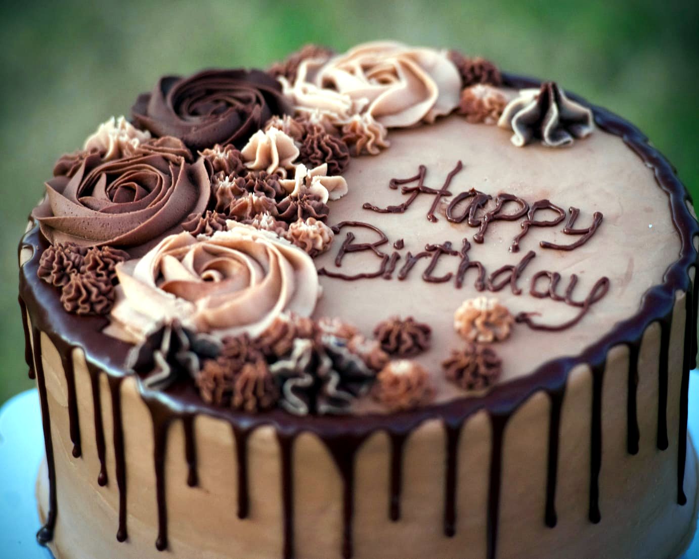 Chocolate drip birthday cake with buttercream roses piped Happy Birthday — baked at Zionie Bake House